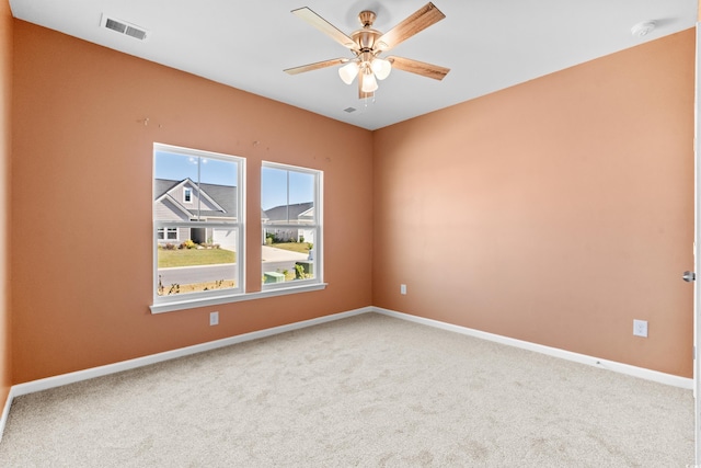 unfurnished room with ceiling fan and carpet