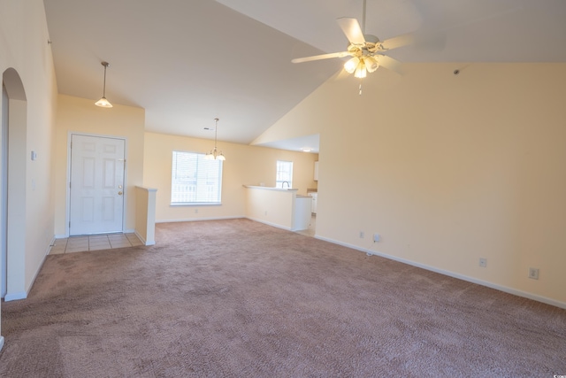 unfurnished living room with arched walkways, light colored carpet, a ceiling fan, high vaulted ceiling, and baseboards