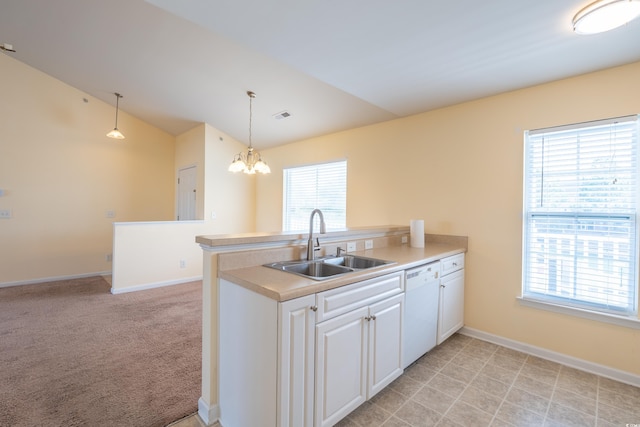 kitchen with white dishwasher, a sink, visible vents, vaulted ceiling, and a wealth of natural light