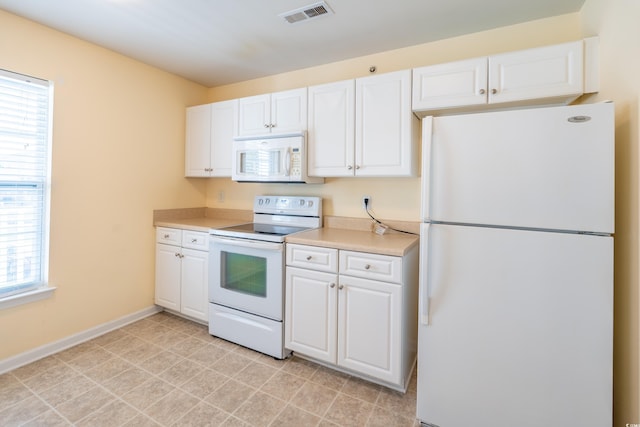 kitchen featuring light countertops, white appliances, visible vents, and white cabinetry