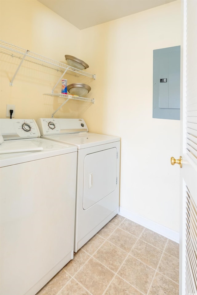 clothes washing area with light tile patterned floors, laundry area, electric panel, independent washer and dryer, and baseboards