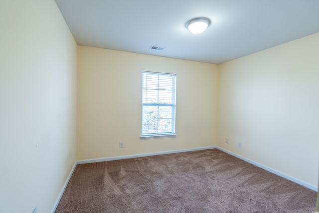 carpeted empty room with visible vents and baseboards