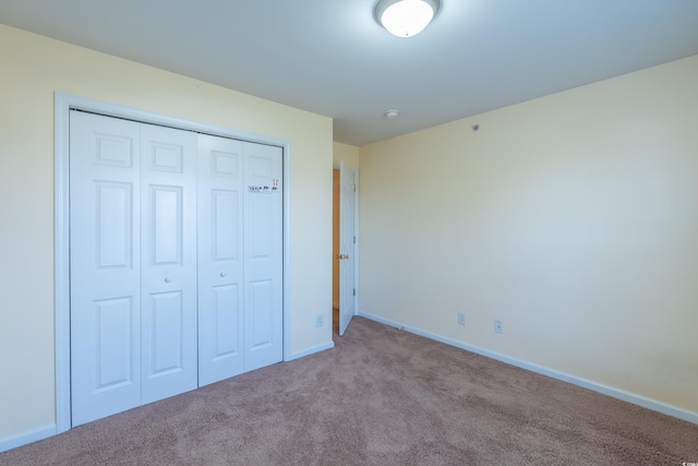 unfurnished bedroom featuring a closet, carpet flooring, and baseboards