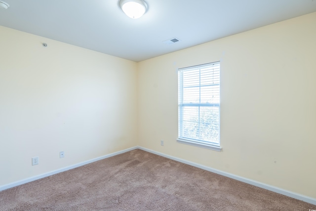 carpeted empty room with baseboards and visible vents