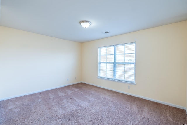 carpeted spare room featuring visible vents and baseboards