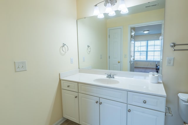 bathroom with visible vents, vanity, and toilet