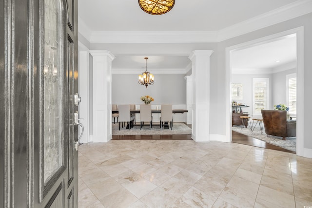 entryway with ornate columns, ornamental molding, and a chandelier