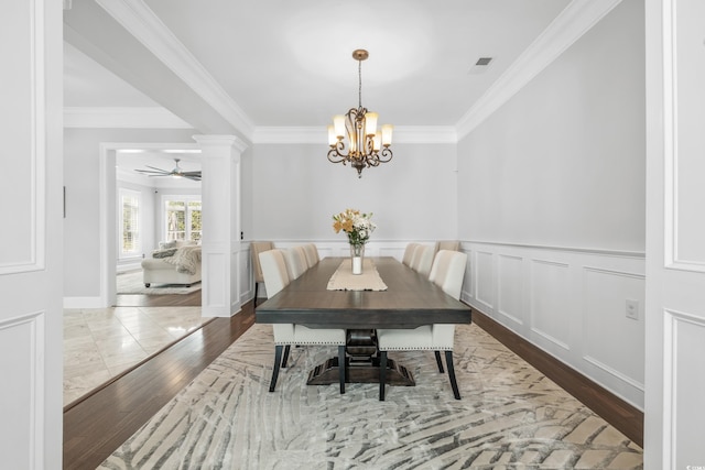 dining space with crown molding, hardwood / wood-style flooring, and ceiling fan with notable chandelier