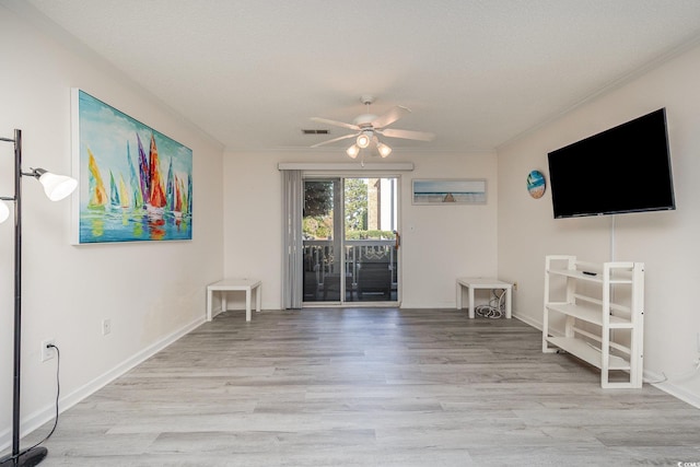 entryway featuring ceiling fan, light hardwood / wood-style floors, a textured ceiling, and ornamental molding