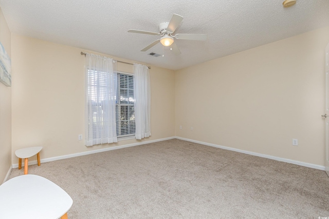 carpeted spare room featuring a textured ceiling and ceiling fan