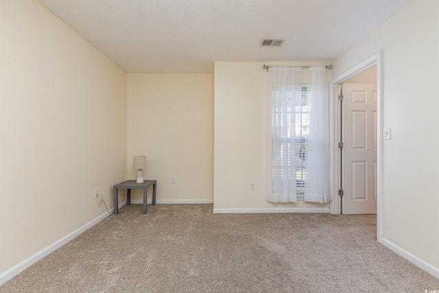 carpeted empty room with a textured ceiling