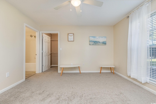 carpeted empty room featuring ceiling fan and a textured ceiling