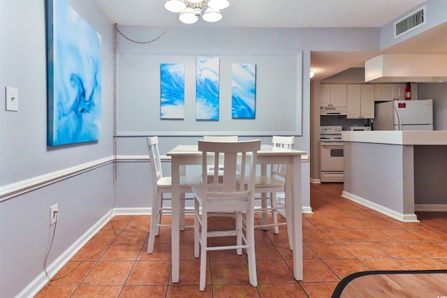 dining room with a notable chandelier and light tile patterned flooring