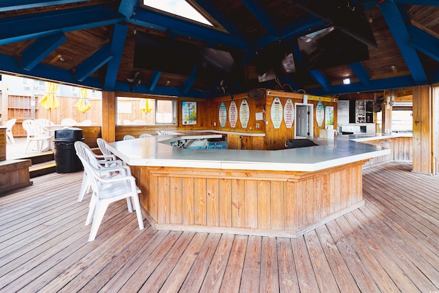 wooden terrace with an outdoor bar and a gazebo