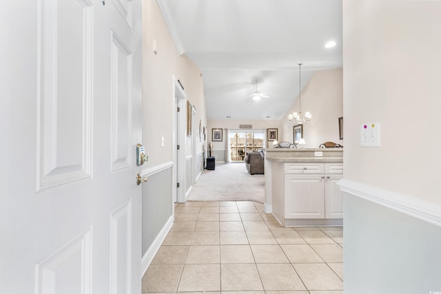 interior space with light tile patterned flooring, a notable chandelier, and high vaulted ceiling