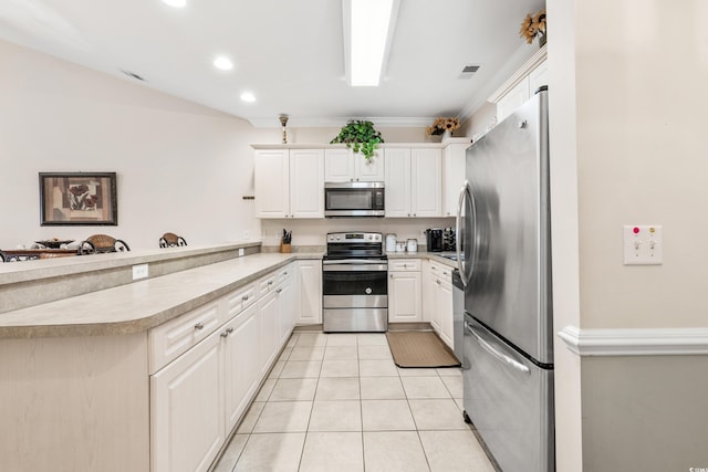 kitchen with white cabinetry, stainless steel appliances, light tile patterned flooring, and kitchen peninsula