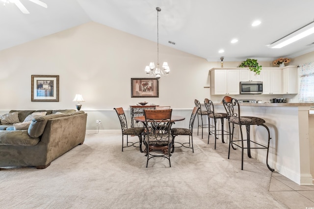 carpeted dining space featuring lofted ceiling and ceiling fan with notable chandelier