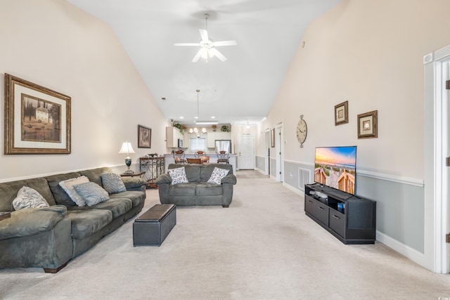 carpeted living room with high vaulted ceiling and ceiling fan