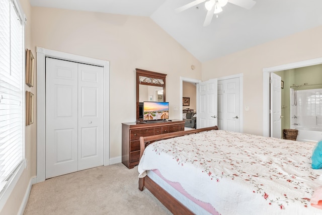 bedroom with light carpet, ensuite bath, vaulted ceiling, and ceiling fan