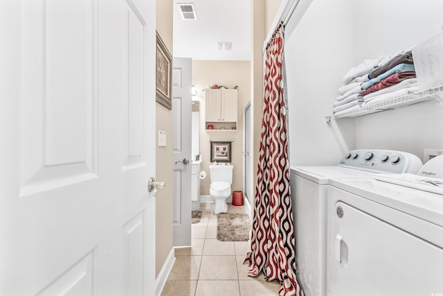 laundry area featuring washing machine and dryer and light tile patterned floors