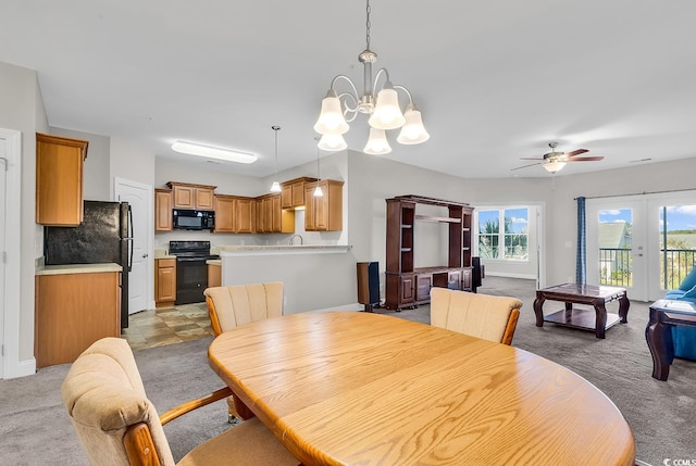 dining area featuring light carpet and ceiling fan with notable chandelier