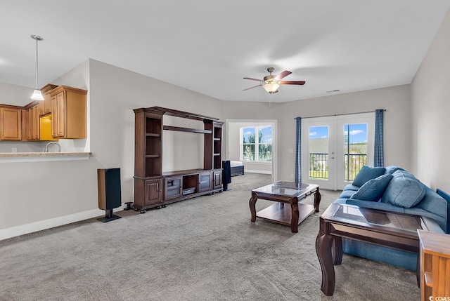 living room with french doors, light carpet, and ceiling fan