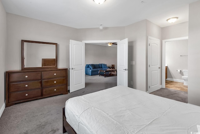 bedroom featuring connected bathroom and carpet flooring