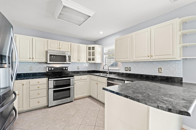 kitchen with tasteful backsplash, appliances with stainless steel finishes, sink, kitchen peninsula, and light tile patterned floors