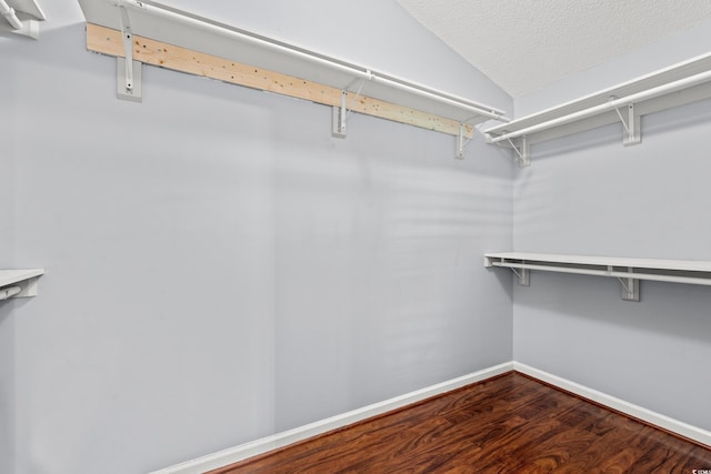 walk in closet featuring hardwood / wood-style floors and vaulted ceiling