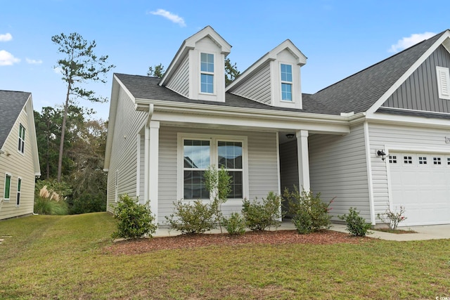 view of front of property featuring a front yard, a porch, and a garage