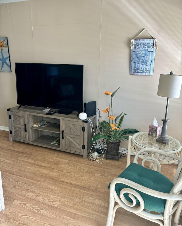 living area with light wood-style flooring and baseboards