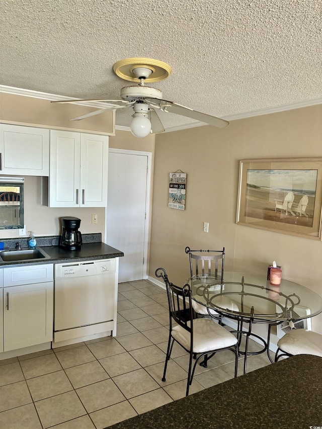 kitchen featuring light tile patterned floors, white cabinets, a ceiling fan, dark countertops, and white dishwasher