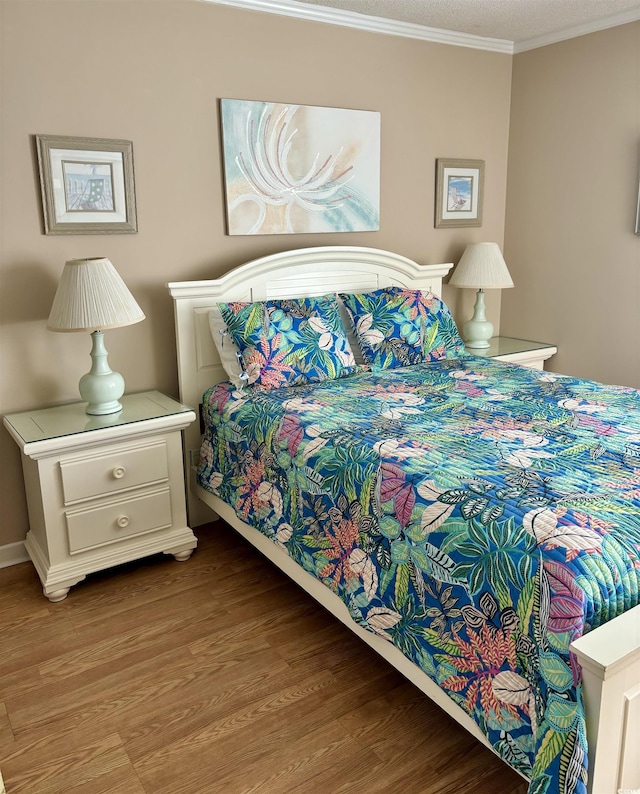 bedroom featuring light wood-style floors and crown molding