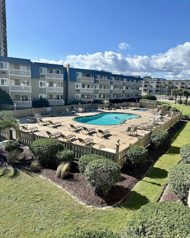 pool with a patio and fence