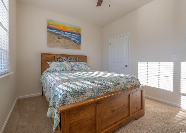 bedroom featuring light carpet, multiple windows, and ceiling fan