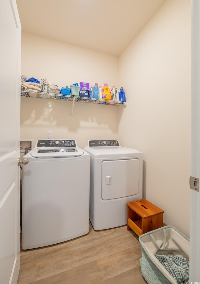 laundry room featuring light wood-type flooring and washing machine and clothes dryer