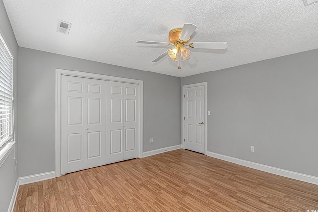 unfurnished bedroom featuring a closet, visible vents, light wood-type flooring, and baseboards