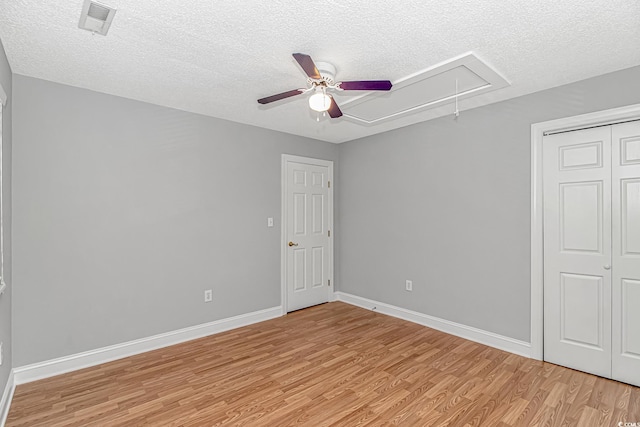 interior space with visible vents, baseboards, attic access, and light wood finished floors