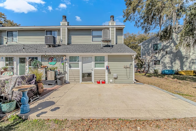 back of property featuring a patio and a shingled roof