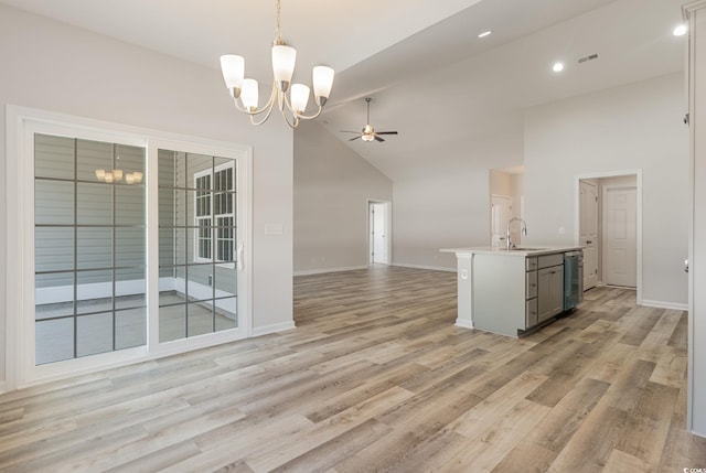 kitchen featuring ceiling fan with notable chandelier, pendant lighting, dishwasher, sink, and light hardwood / wood-style flooring