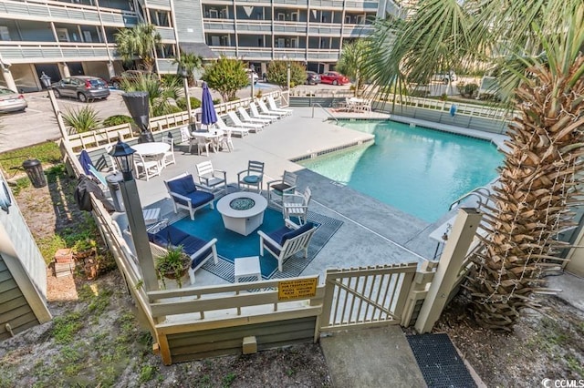 pool with a fire pit and a patio area