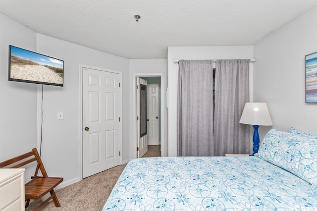 bedroom with a textured ceiling and light colored carpet