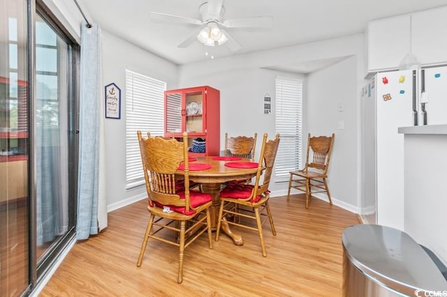 dining room with baseboards, light wood-style flooring, and ceiling fan