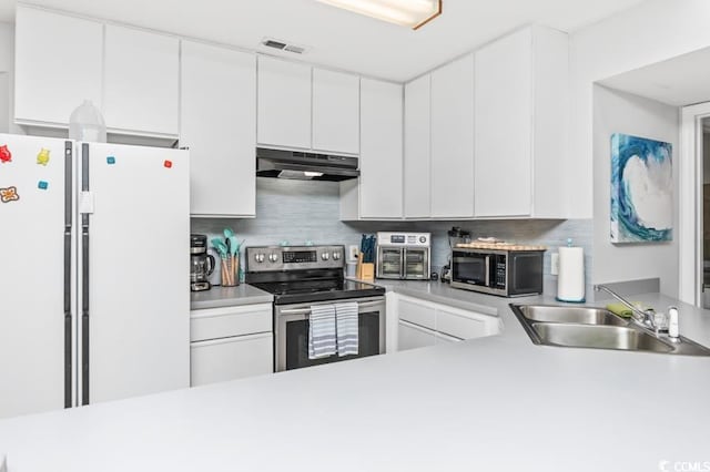 kitchen with backsplash, stainless steel appliances, sink, and white cabinets