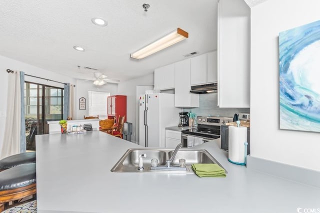 kitchen with kitchen peninsula, stainless steel electric range, ceiling fan, white cabinetry, and white refrigerator