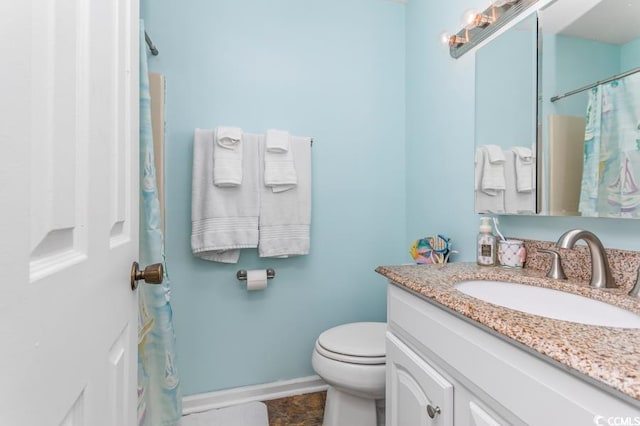 bathroom featuring vanity, baseboards, and toilet