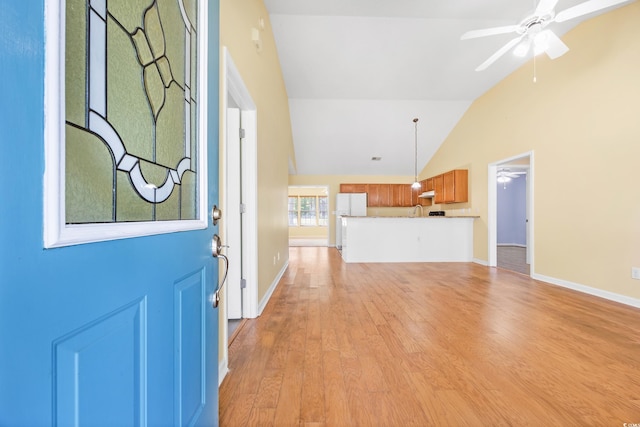 entryway with lofted ceiling, sink, light wood-type flooring, and ceiling fan