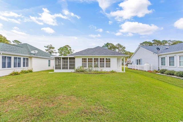 back of property featuring a lawn and a sunroom