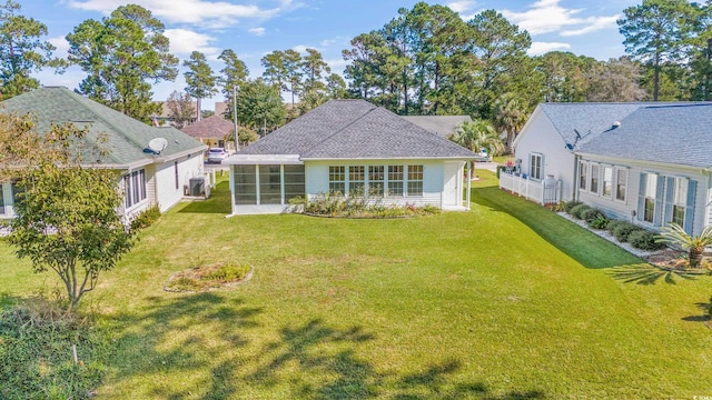 rear view of house with a sunroom and a lawn