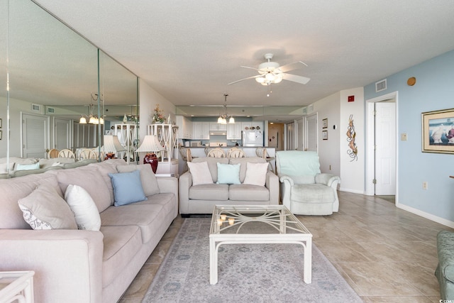 living room with a textured ceiling and ceiling fan with notable chandelier